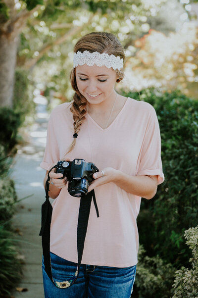 Young Noël Brower looks down at her camera and smiles