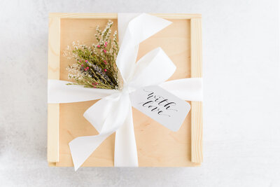 Wood box with custom calligraphy gift tag in black ink and white satin ribbon