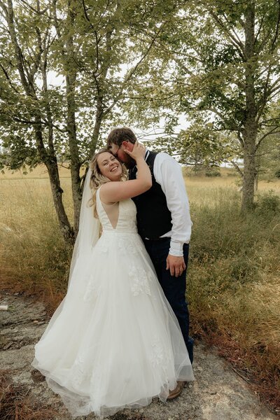 Bride and groom posing in a field