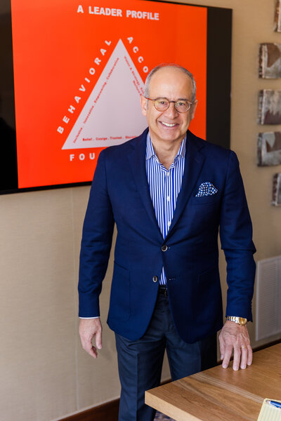 Ahmet Bozer standing in front of a conference room screen, smiling at the camera during his Buckhead Atlanta personal branding session