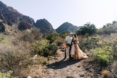 Big Bend elopement photographer captures a tender family moment in the desert mountains of West Texas, with golden light, cacti, and rugged peaks framing the scene.