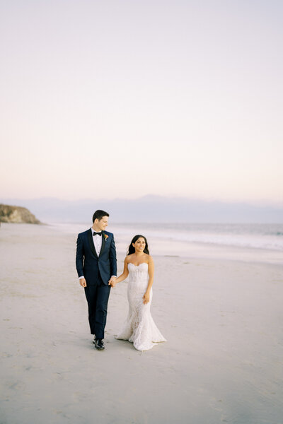 Bride and groom walk on the beach at One and Only Mandarina
