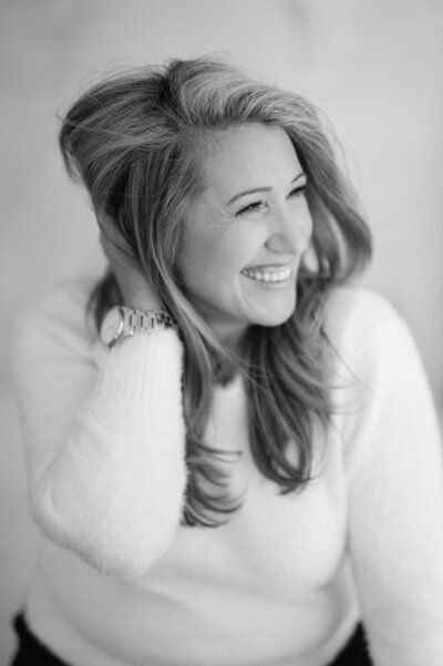 Portrait of Suzanne Karp, owner of Little Palm Photography, sitting in her natural light studio. A friendly and welcoming image capturing her warmth and personality.