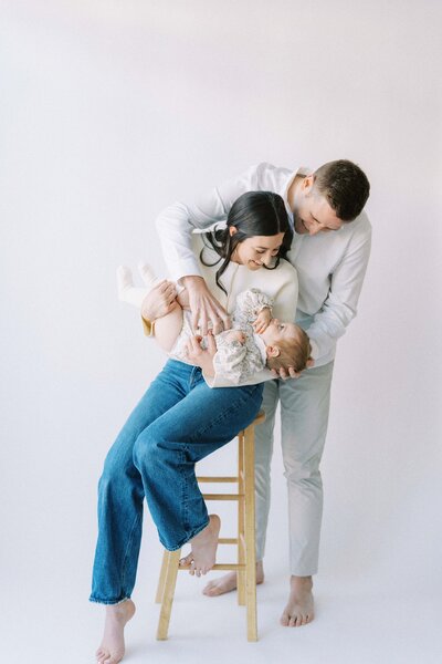parents tickling a baby during a studio photography session