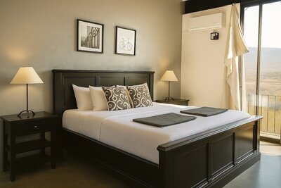 Elegant king-size bed in Casa Barragán with neutral tones, large windows, and serene mountain views