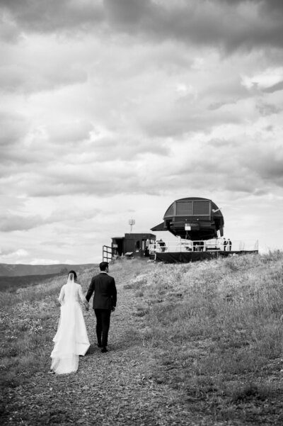 Couple walks towards gondola at Buttermilk wedding. 