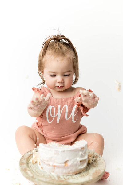 One year old girl smash her cake for her photo session.