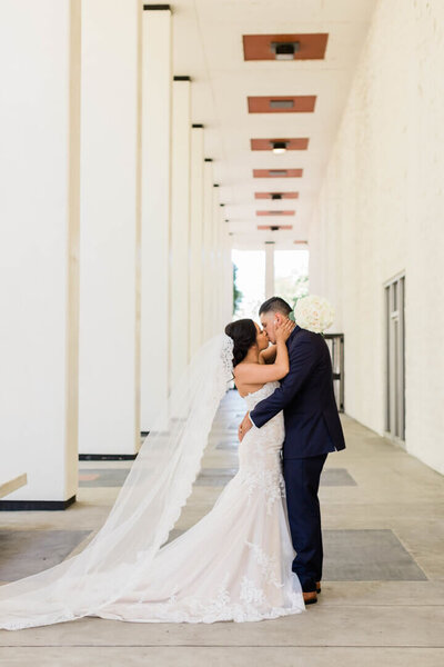 bride and groom share a kiss outside of the public library