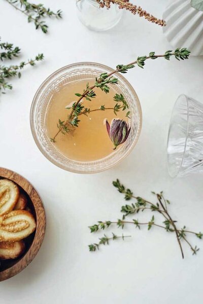Crystal cup of bone broth with thyme sprig