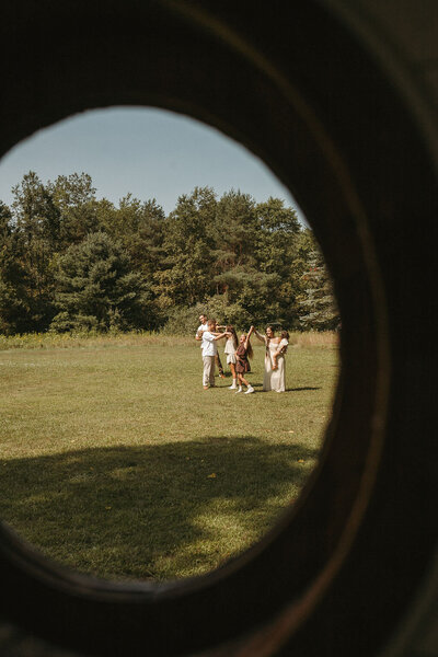 View from inside capturing a family playing together outside through the window