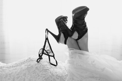 Stilettos holding thong in wedding dress