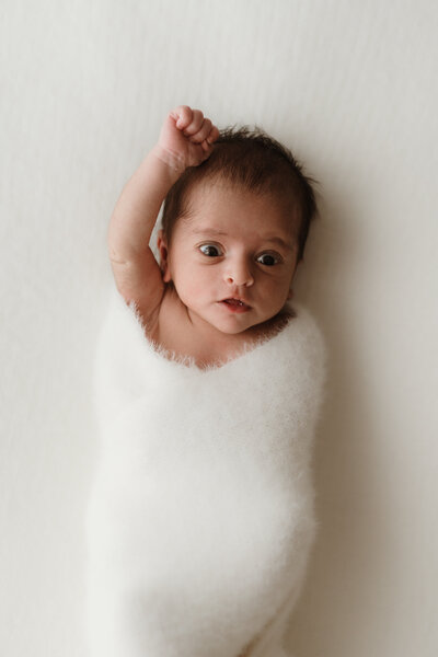 Baby stretching on white beanbag