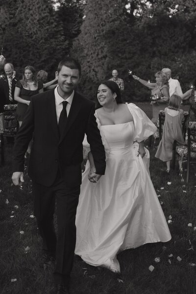 black and white photo of bride and groom walking down the aisle after getting married