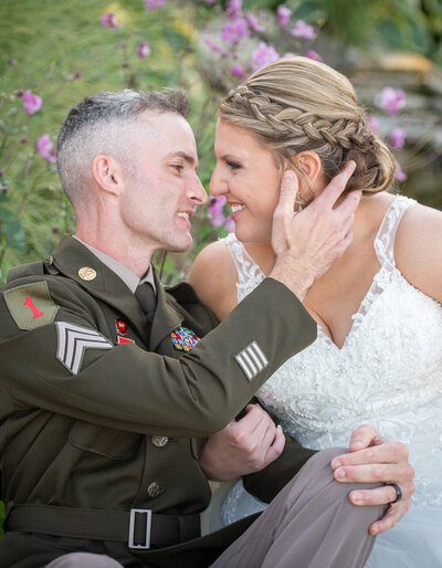 grooms holds brides face amongst flowers