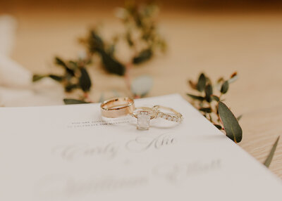 Close up of wedding ring set on wedding invitation