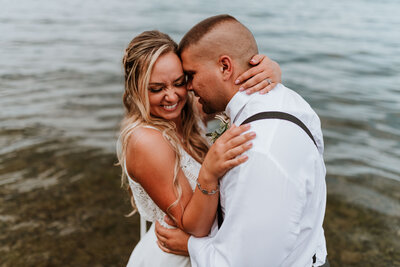 Married couple laughing and hugging while in the lake