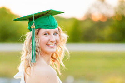 Senior girl wearing a green cap in a field