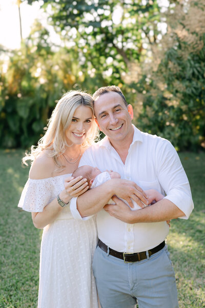 Black and white dad and mom holding newborn baby by Miami Newborn Photography