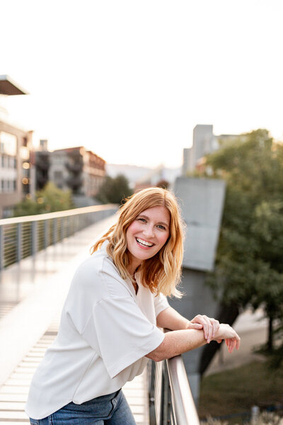 woman standing on a bridge smiling