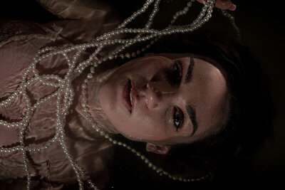 Fine art wedding photography in Edinburgh bride lays in a bath of water surrounded by pearls