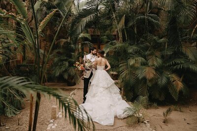 Bride and Groom Pose Among Palm Trees At their Stunning Mexico Wedding