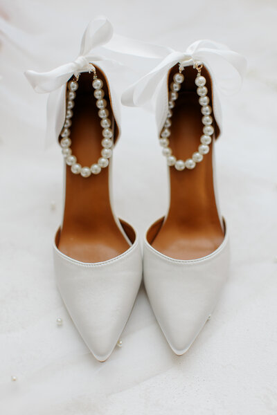 White bridal heels with pearls and white ribbon bows