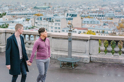Gay couple holding hands after a romantic proposal near Sacré-Cœur in Montmartre during a Paris photoshoot.
