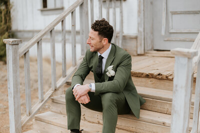 groom sitting on stairs looking out