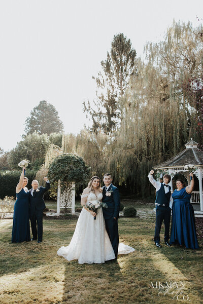 Brides kissing by willow tree