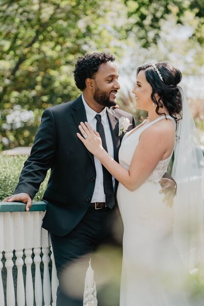 Interracial couple stand in classic editorial wedding pose.  