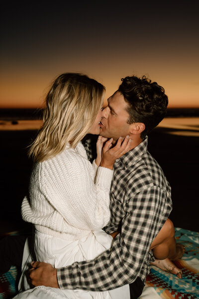 couple kissing on the beach at sunset