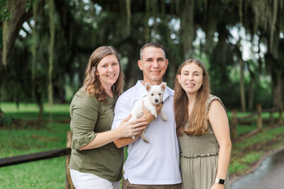 family with an older kid and dog hugging for fall family session