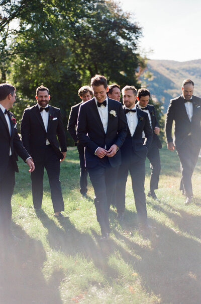 A groom walks with his groomsmen