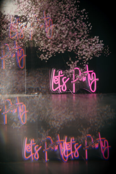 A neon sign saying "Let´s party".