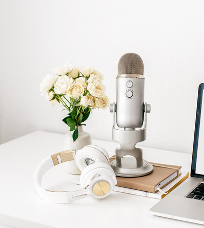 Microphone and headphones with flowers on desk