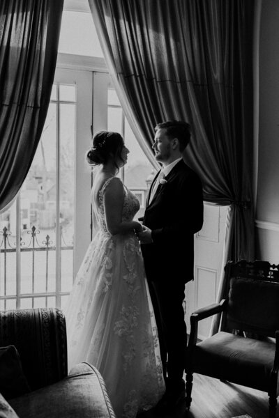 The bride and groom admiring each other after their first look, in black and white.