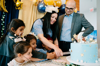 Family cutting birthday cake together