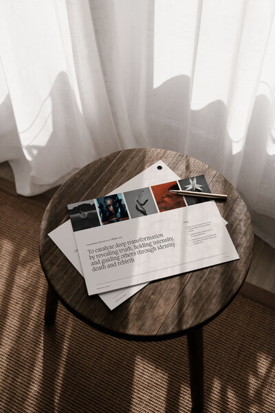 Flat lay of brand strategy documents and creative direction guide on a wooden table, part of the Moonstone Brand Star Chart process.