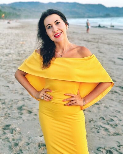 Life coach Ana-Maria Georgieva in a yellow dress on a beach