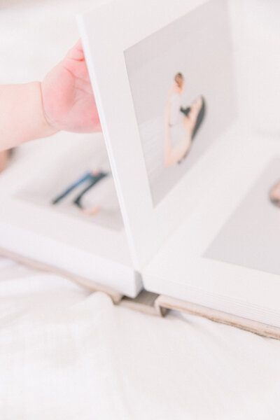 Little baby's hand turning album page taken by Sacramento Newborn Photographer Kelsey Krall Photography