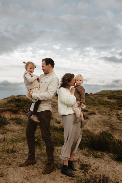 Gezinsfotoshoot in de duinen van Wassenaar met ouders en twee jonge kinderen in warm, natuurlijk licht door Linda Photography