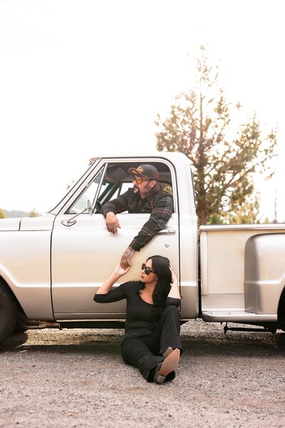 country couple kissing near old truck