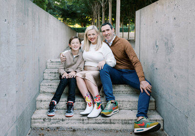 Mom, Dad, and son sitting closely together on the steps during a family photo session in Fort Worth TX