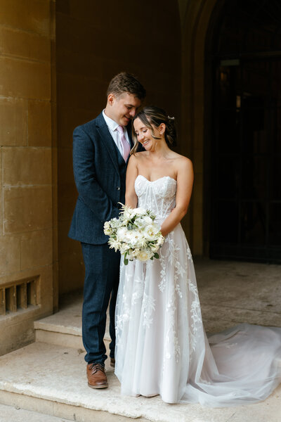 Groom giving bride a piggyback ride at outdoor reception