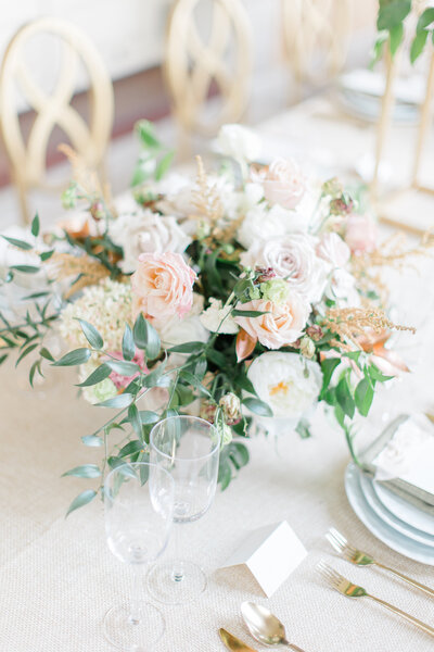 Pink and white floral table centerpiece with greenery