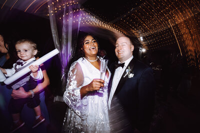 A biracial couple parties on the dance floor at their reception