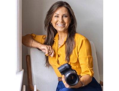Woman in a yellow blouse holding a camera