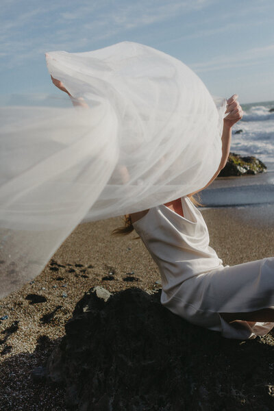 Soft editorial bridal wedding photography of a bride throwing her veil. Wedding photography on the Sonoma Coast.