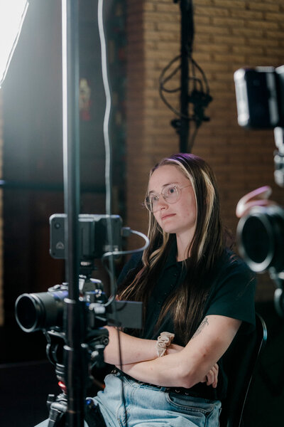 a woman listens to an interview subject from behind multiple cameras