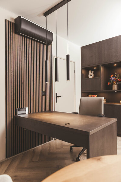 Een rustige en moderne werkomgeving met bureau, lattenwand en inbouwkast.
